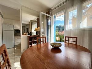 une grande table en bois dans une cuisine avec une grande fenêtre dans l'établissement Appartement F2 ensoleillé avec terrasse et parking, proche des Thermes et centre-ville - FR-1-703-178, à Amélie-les-Bains-Palalda
