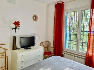 une chambre avec un lit, une télévision et une fenêtre dans l'établissement Appartement F2 ensoleillé avec terrasse et parking, proche des Thermes et centre-ville - FR-1-703-178, à Amélie-les-Bains-Palalda