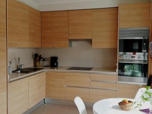 Apartamento Platja d'Aro, 2 dormitorios, 4 personas - ES-209-77 في مدريد: مطبخ بدولاب خشبي وطاولة بيضاء