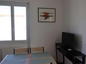 un salon avec une table et une télévision dans l'établissement Appartement Royan, 2 pièces, 2 personnes - FR-1-494-187, à Royan
