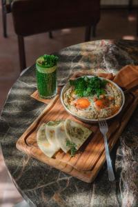 einen Tisch mit einer Schüssel Suppe und einem Teller Brot in der Unterkunft Rimbun Canggu Hotel in Canggu