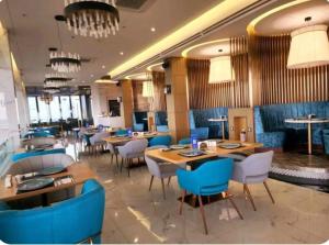 a restaurant with wooden tables and blue chairs at One Euphoria walking st Condotel Angeles city in Angeles