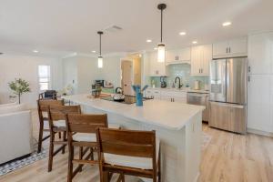 a kitchen with a large island with chairs in it at Oceanview Retreat/Perfect for Groups/Heated Pool in Fort Myers Beach