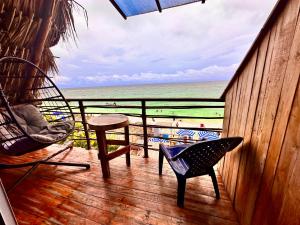 普拉亞布蘭卡的住宿－BARU MAGGYBEACH，一个带椅子和桌子的门廊,享有海滩美景