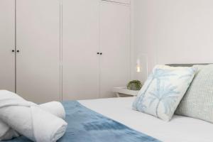 um quarto com armários brancos e uma cama com uma almofada em Stunning Cosy 1BR Apartment in heart of Elwood em Melbourne