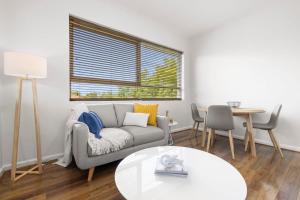uma sala de estar com um sofá e uma mesa em Stunning Cosy 1BR Apartment in heart of Elwood em Melbourne