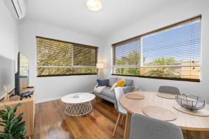 a living room with a table and a couch at Stunning Cosy 1BR Apartment in heart of Elwood in Melbourne