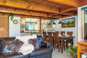 a living room with a leather couch and a table at Rakaia Gorge Views - Mt Hutt in Windwhistle