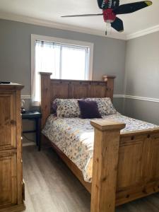una camera con letto in legno e ventilatore a soffitto di Adorable Home Away from Home a Corpus Christi