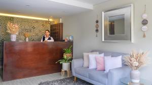 a woman standing at a counter in a room with a couch at El puente Hotel Boutique in Arequipa