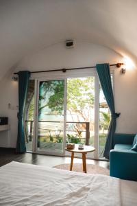 a bedroom with a bed and a large glass window at Tube Resort By EHM in Koh Rong Sanloem