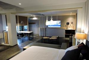 um quarto com uma cama e uma sala de estar com uma cozinha em Roppongi Motel - Dalian em Pingtung City