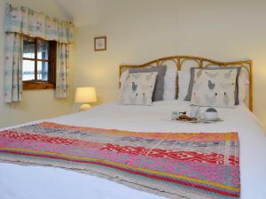 um quarto com uma grande cama branca e um cobertor em Cefn Canol em Betws-y-coed