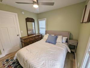 ein Schlafzimmer mit einem Bett mit einer Kommode und einem Spiegel in der Unterkunft Sleek and Central Small Home Close to everything in Flint