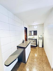 a white kitchen with a bench in a room at Rainbow Hotel in Alor Setar