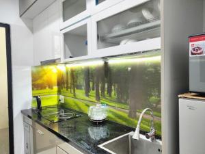 a kitchen with a counter with a painting on the wall at Happiest Homestay 1 - Manor Crown Hue in Hue