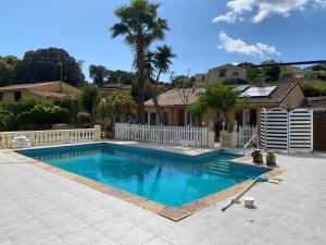 einen Pool in einem Garten mit einem weißen Zaun in der Unterkunft Maison Ajaccio, 5 pièces, 6 personnes - FR-1-665-36 in Ajaccio