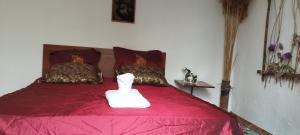 a bedroom with a red bed with a statue on it at Guest house on Akmatbai-Ata 29 in Cholpon-Ata