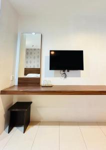 a desk with a television on a wall with a mirror at Rainbow Hotel in Alor Setar