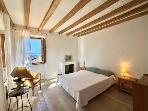 ein Schlafzimmer mit einem weißen Bett und einem Fenster in der Unterkunft Maison Pietrosella, 3 pièces, 4 personnes - FR-1-61-631 in Pietrosella