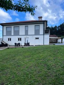a large white building with benches in a yard at Casa Alexandre 7 in Monte