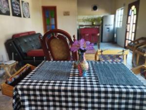 a table with a vase with purple flowers in it at Bio-Hotel entre café, bosque y montañas in Cachipay