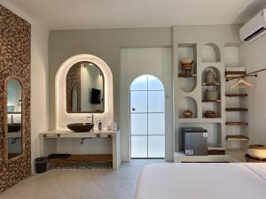 1 dormitorio con lavabo y espejo en El Tropico Boutique Hotel en Kuta Lombok