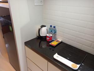 a kitchen counter with a blender and water bottles on it at SleepRest @ Pollux Habibie in Batam Center