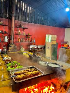 a kitchen with a bunch of food on a grill at Hotel Fazenda Rancho Mineiro in Engenheiro Paulo de Frontin