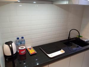 a kitchen counter top with a sink and a counter top at SleepRest @ Pollux Habibie in Batam Center