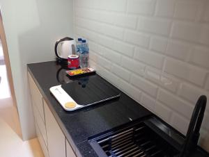 una cocina con encimera negra y fregadero en SleepRest @ Pollux Habibie en Batam Center