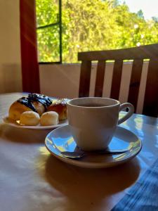 een kop koffie en twee donuts op een tafel bij Hotel Fazenda Rancho Mineiro in Engenheiro Paulo de Frontin