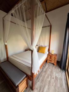 a bedroom with two beds and a canopy bed at ANITSA RESORT in El Nido
