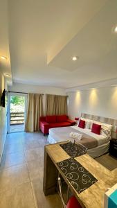 a hotel room with two beds and a red couch at Ayres Village Apart in Pinamar