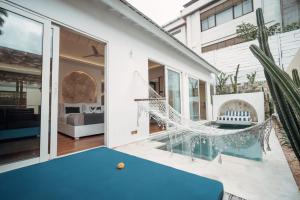 a patio with a pool table and a hammock at Aleva Villa Seminyak by Ini Vie Hospitality in Seminyak
