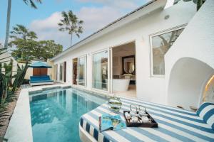 a swimming pool next to a house at Aleva Villa Seminyak by Ini Vie Hospitality in Seminyak