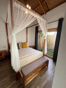 a bedroom with a bed with a mosquito net at ANITSA RESORT in El Nido
