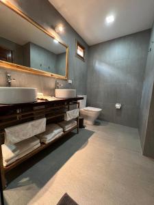 een badkamer met een wastafel, een toilet en een spiegel bij ANITSA RESORT in El Nido