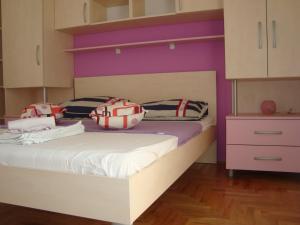 duas camas num quarto com paredes roxas e roxas em Apartments Kiro em Milna