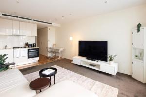 uma sala de estar com uma grande televisão de ecrã plano em Spencer St Serenity Stylish 1-Bedroom Apartment Escape em Melbourne