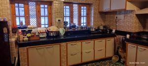 a kitchen with a black counter top and some windows at ID VILLA in Gulmarg