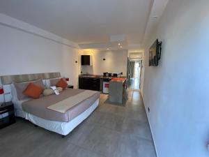a bedroom with a large bed and a kitchen at Ayres Village Apart in Pinamar