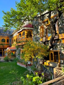 ein großes Steinhaus mit einem Baum im Hof in der Unterkunft Lavender Cottage and Guest House in Skardu