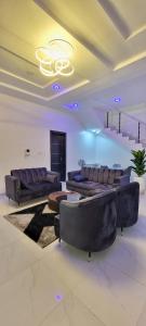 ein großes Wohnzimmer mit Sofas und einem Kronleuchter in der Unterkunft Blue Luxury in Awoyaya
