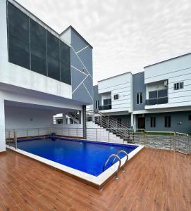 una casa con piscina frente a un edificio en Blue Luxury, en Awoyaya