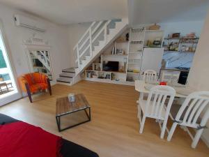 een woonkamer met een trap en een tafel en stoelen bij Maison Le Grau d'Agde, 3 pièces, 6 personnes - FR-1-423-302 in Le Grau-dʼAgde
