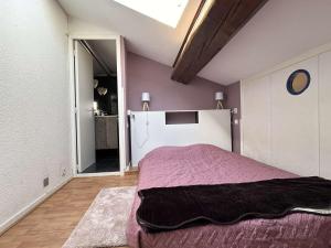 Un dormitorio con una cama con una manta morada. en Duplex central à Banyuls-sur-Mer, 4 couchages, plage et commerces à proximité - FR-1-225C-141, en Banyuls-sur-Mer