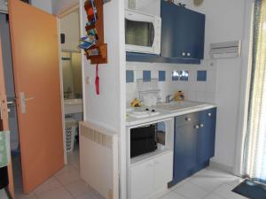 a small kitchen with a sink and a microwave at Maison Vendres, 3 pièces, 4 personnes - FR-1-701-82 in Vendres