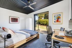 a bedroom with a bed and a desk with a computer at Sanctuaire, Southern Highlands in Mittagong