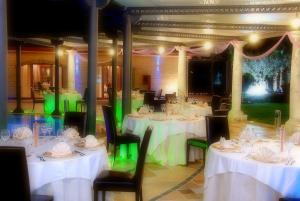 a dining room with white tables and black chairs at Villa Masseria Marini in San Giuseppe Vesuviano